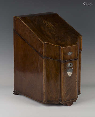 A George III mahogany serpentine fronted knife box, the sloping lid with an inlaid shell patera, the