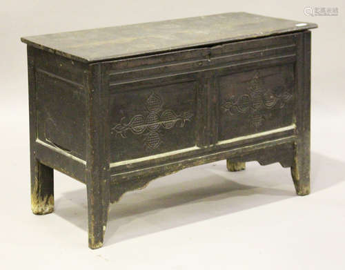 A late 17th century oak panelled coffer, the lid with original wire hinges above a carved front,