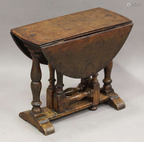 A 20th century Jacobean Revival stained oak oval drop-flap occasional table, height 50cm, width