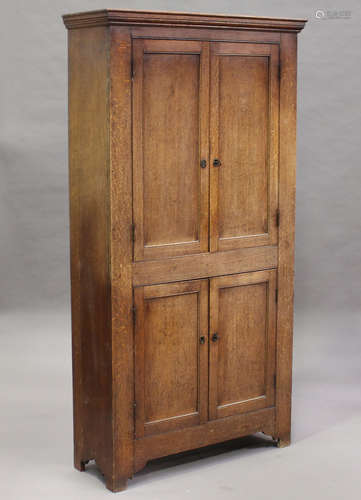 A 19th century provincial oak two-tier side cupboard, enclosed by four panelled doors enclosing