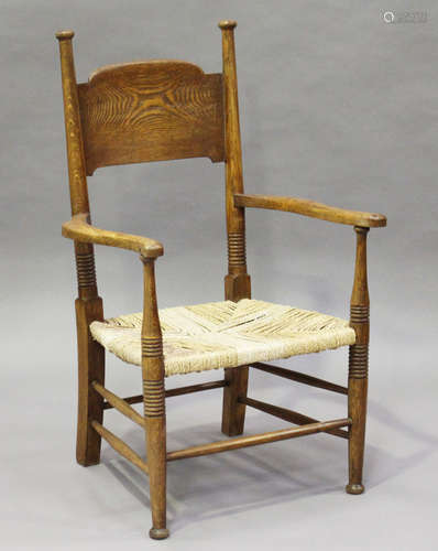 An early 20th century Arts and Crafts ash panel back elbow chair, designed by E.G. Punnet for