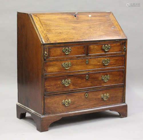 A small George III mahogany bureau, the fall-flap enclosing a fitted interior above oak-lined