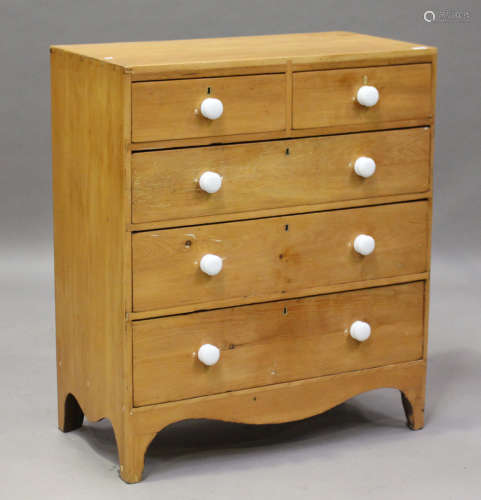A late George III pine chest of drawers with applied white ceramic handles, on bracket feet,