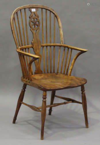 A mid-Victorian ash and elm stick and wheel back Windsor armchair, the shaped seat panel on turned