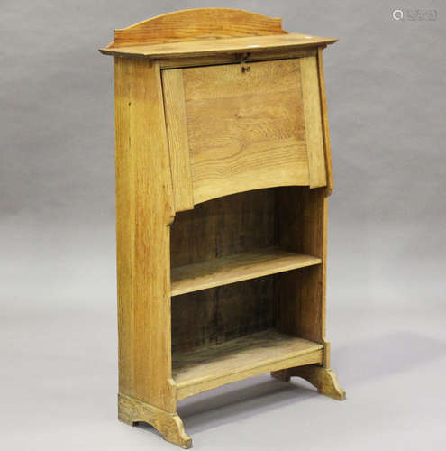 An Edwardian Arts and Crafts oak student's bureau, the fall-flap above open shelves, height 122cm,