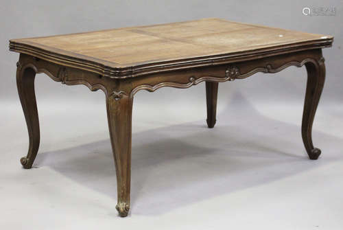 A 20th century French oak extending draw-leaf dining table, raised on cabriole legs, height 75.