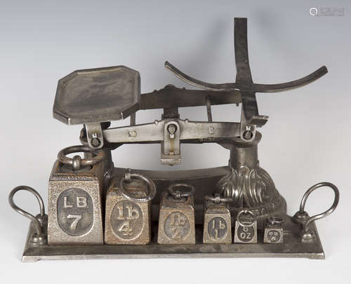 A late Victorian polished steel counter-top balance scale, the twin-handled base fitted with six