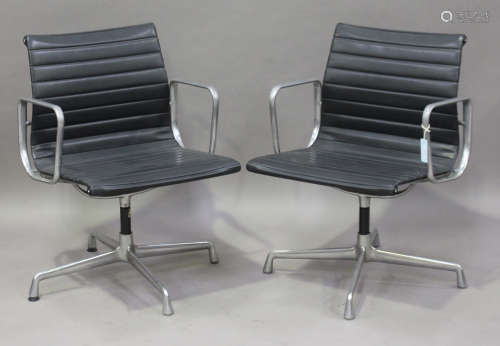 A pair of EA 108 cast aluminium and black leather revolving armchairs, made by Vitra and designed by