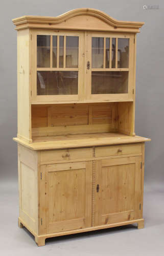 A 20th century Continental pine dresser with arched glazed top and open shelf, the base fitted