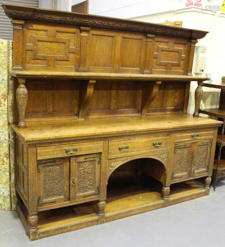 A large late Victorian Aesthetic Movement oak sideboard, the panelled shelf back above three drawers