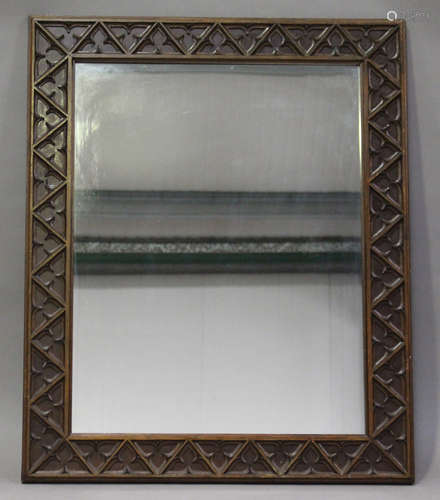 An early 20th century Gothic Revival stained softwood wall mirror with a carved tracery frame, 103cm