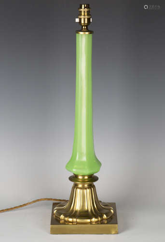 A late Victorian gilt bronze and green glass table lamp, the faceted octagonal stem raised on a