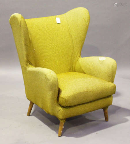 A mid-20th century wing back armchair by Howard Keith, raised on tapering legs, height 100cm,