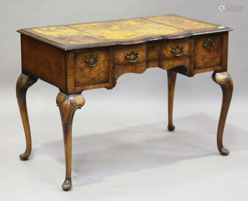 An early 20th century Queen Anne style walnut writing table, raised on carved cabriole legs,