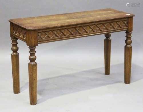 A late 19th/early 20th century Gothic Revival oak hall table, the carved blind fretwork frieze