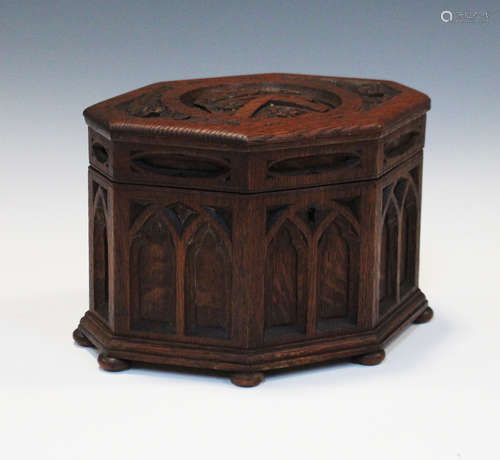 An early 20th century Gothic Revival oak octagonal musical casket, the hinged lid carved with an