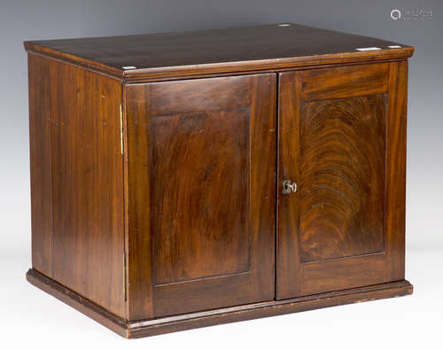 A late 19th century figured mahogany table-top collector's cabinet, the two panelled doors enclosing