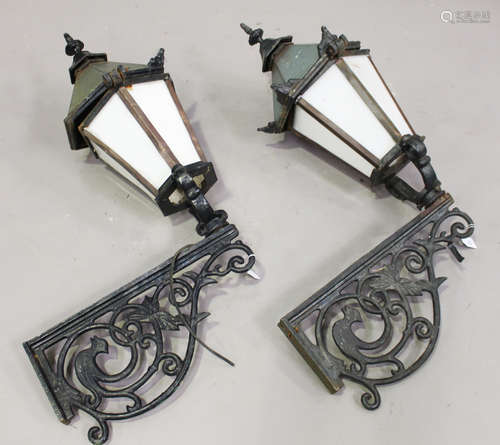 A pair of 20th century Continental cast iron wall mounted street lanterns with foliate scrolling