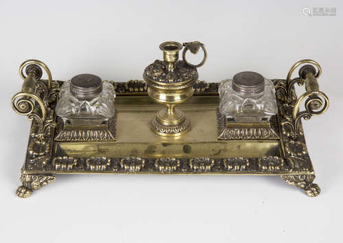 A 19th century cast brass inkstand, fitted with a central candle holder flanked by a pair of cut