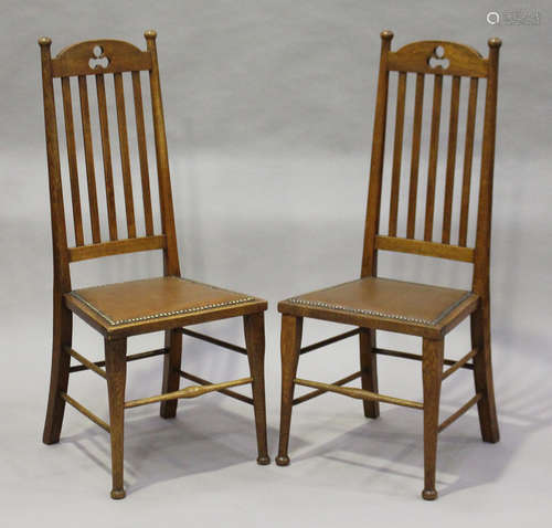 A pair of Edwardian Arts and Crafts oak framed side chairs, probably Scottish, the arched top