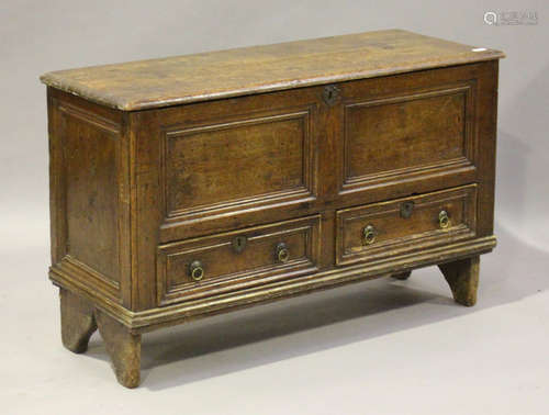 An 18th century stained pine mule chest, the hinged lid above two drawers, on shaped end supports,