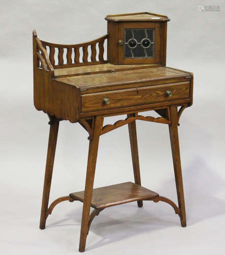 An Edwardian Arts and Crafts stained ash writing table, in the manner of Liberty & Co, the gallery