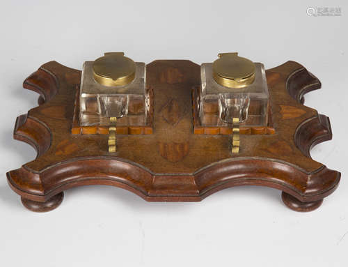 An early 20th century mahogany and satinwood inkstand, fitted with two glass inkwells on a