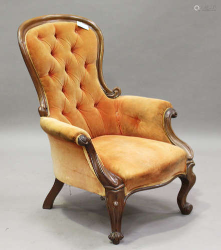 A mid-Victorian walnut showframe salon armchair with a foliate carved crest and cabriole legs,