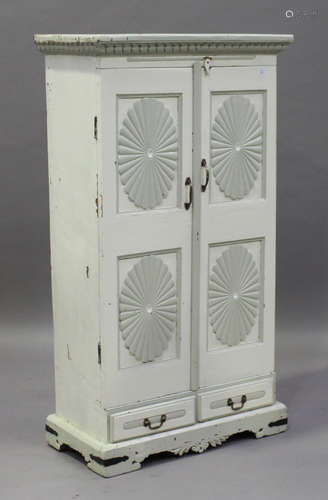 A 20th century painted hardwood side cabinet, the two panelled doors with carved rosettes above