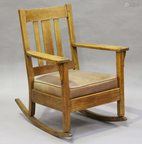 An early 20th century American Mission Arts and Crafts oak framed rocking armchair, in the manner of