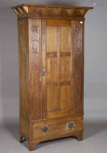 An Edwardian Arts and Crafts oak wardrobe, in the manner of Shapland & Petter, the overhanging