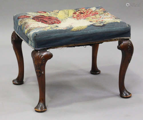 An early 20th century Queen Anne style walnut stool, raised on shell-carved cabriole legs and pad