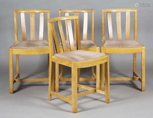 A set of four early 20th century Heals pale oak comb back dining chairs with drop-in seats,