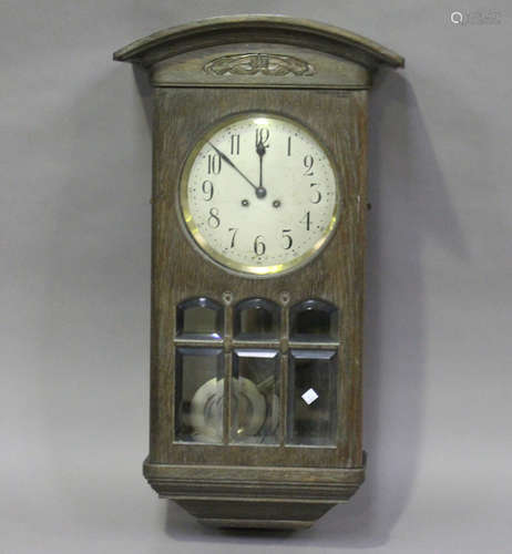 An early 20th century Arts and Crafts style oak wall clock with eight day chiming movement, height