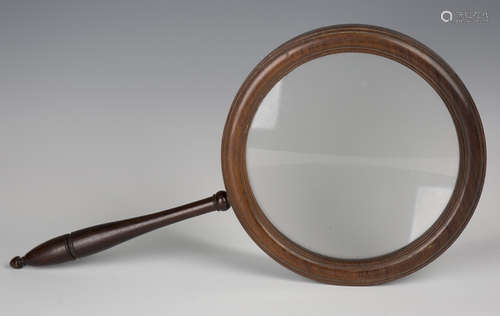 A 19th century rosewood gallery glass, the large circular frame supporting a glass lens, length 45.