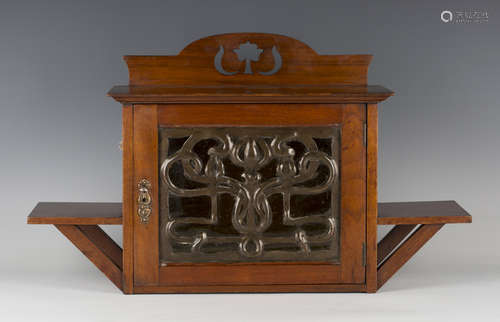 An Edwardian Arts and Crafts mahogany wall cabinet by Shapland & Petter of Barnstaple, the glazed