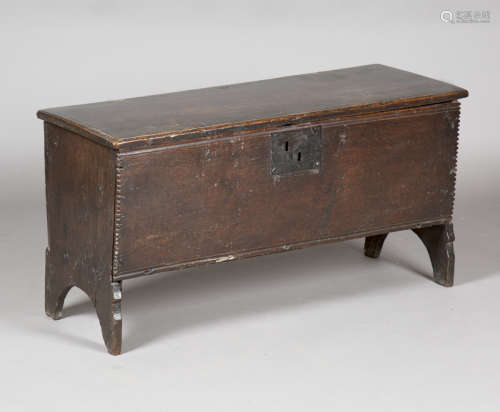 A mid-17th century oak six-plank boarded coffer, the lid with wire hinges above a chip carved