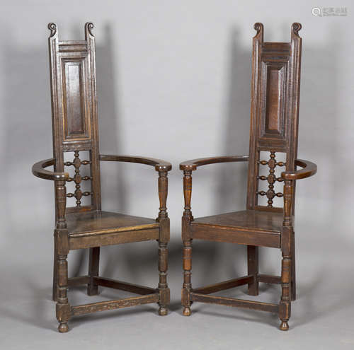 A near pair of early 20th century Arts and Crafts stained oak 'Shakespeare' armchairs, in the manner