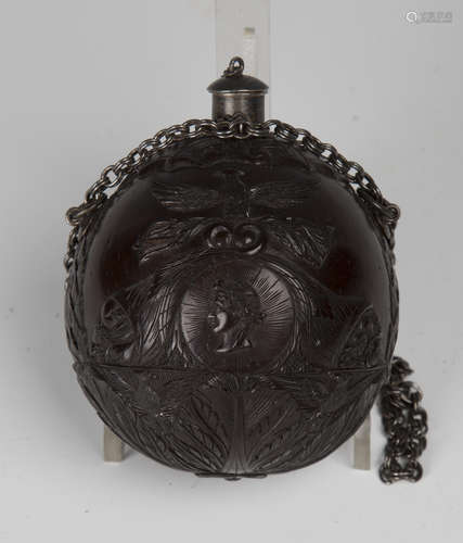 An early 19th century finely carved coconut bugbear powder flask of Napoleonic interest, one end