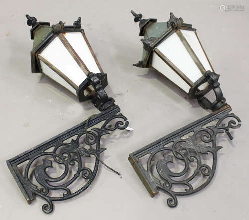 A pair of 20th century Continental cast iron wall mounted street lanterns with foliate scrolling