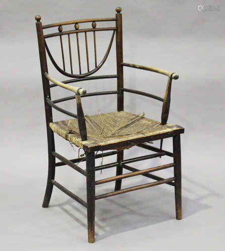 A late Victorian stained beech Sussex type armchair, possibly by Morris & Co, the unusual curved