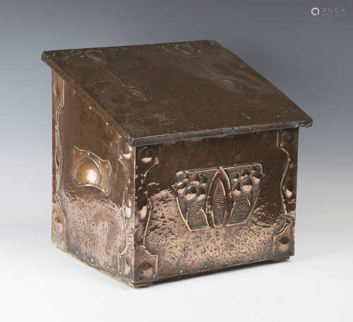 A late 19th/early 20th century Arts and Crafts copper mounted log box, the sloping hinged lid worked