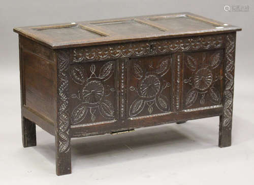 A late 17th century oak panelled coffer, the triple-panel front carved with foliate arabesques and