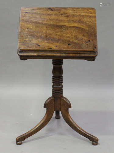 A George IV mahogany tilt-top reading table, fitted with a pair of candle stands, the ring turned