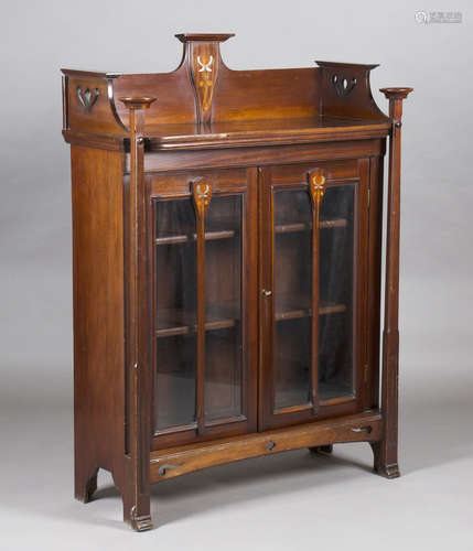 An Edwardian Arts and Crafts mahogany glazed bookcase, in the manner of Wylie & Lochhead, inlaid