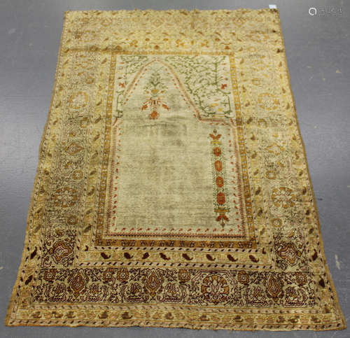 A Turkish silk prayer rug fragment, late 19th/early 20th century, the ivory mihrab with arch and