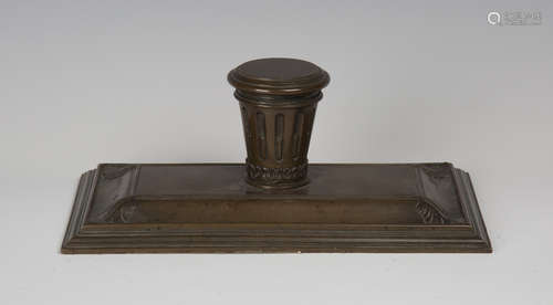 A 19th century brown patinated cast bronze inkstand, the central stop fluted inkwell with hinged