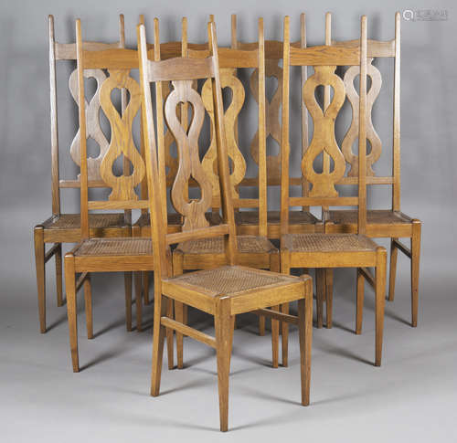 A set of eight Arts and Crafts oak framed chairs, after a design by Charles Francis Annesley Voysey,