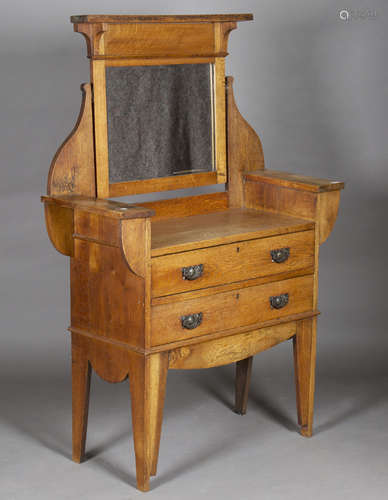 An Edwardian Arts and Crafts oak dressing chest, fitted with a swing mirror and two drawers,