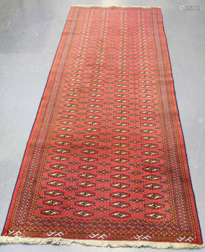 An Afghan runner, late 20th century, the red field with overall columns of guls, within a striped